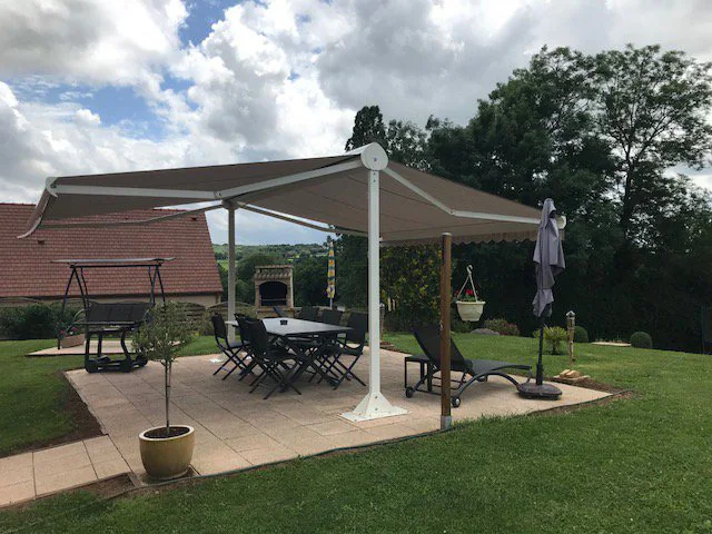 Store terrasse double pente crème au-dessus d'un salon de jardin