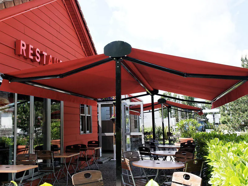 Store terrasse double pente rouge devant un restaurant