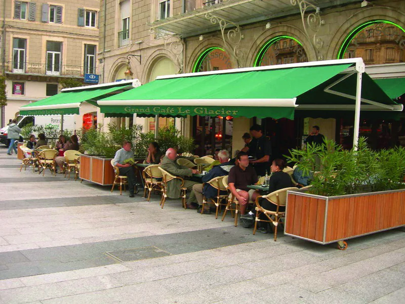 Store terrasse double pente vert sur la terrasse d'un café de centre-ville