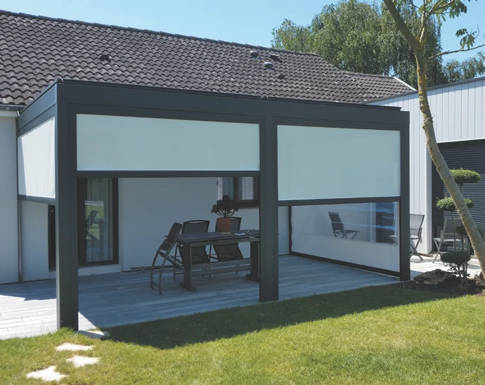 Deux stores verticaux écrus installés en angle sur la terrasse couverte d'une maison