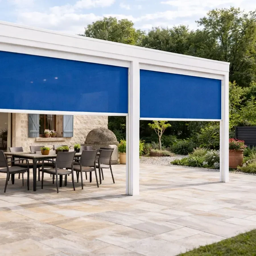 Pergola blanche RAL 9010 équipée de deux stores verticaux Tibelly bleus, terrasse en pierre