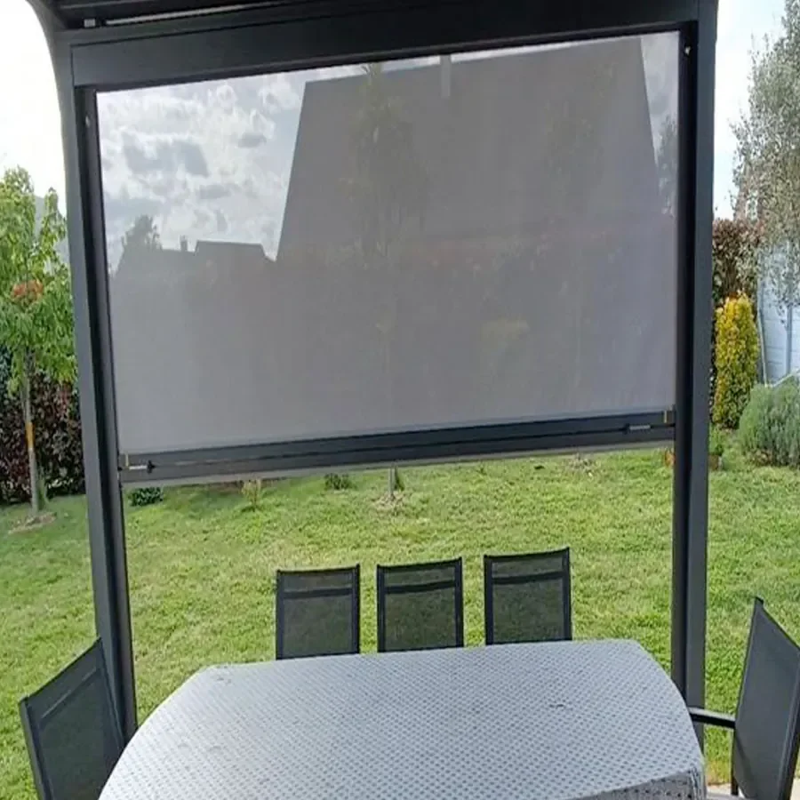 Vue depuis un salon de jardin sous pergola : la toile Sunworker Open laisse voir l'extérieur