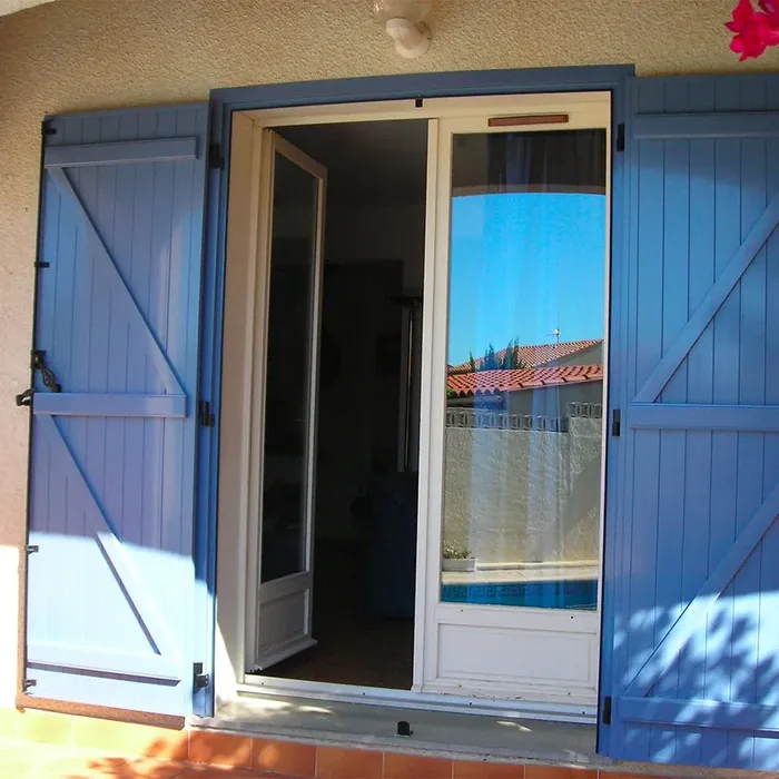Volet battant aluminium bleu avec barre et écharpe, sur une porte-fenêtre