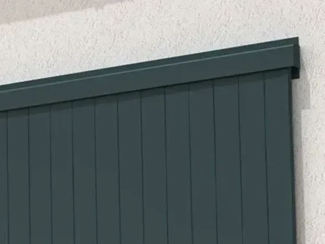 Détail du rail haut d'un volet coulissant aluminium, posé en applique sur la façade