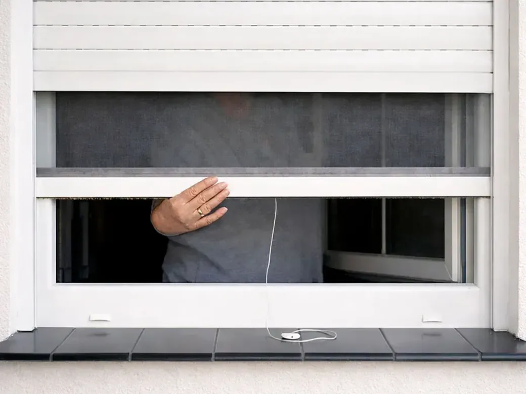 Moustiquaire intégrée partiellement relevée, vue depuis l’intérieur, fenêtre ouverte