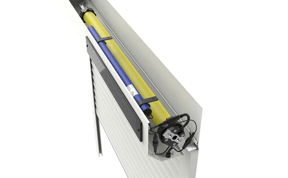 Coupe du coffre d'un volet roulant solaire Avosdim : tube d'enroulement, batterie lithium, moteur et câblage