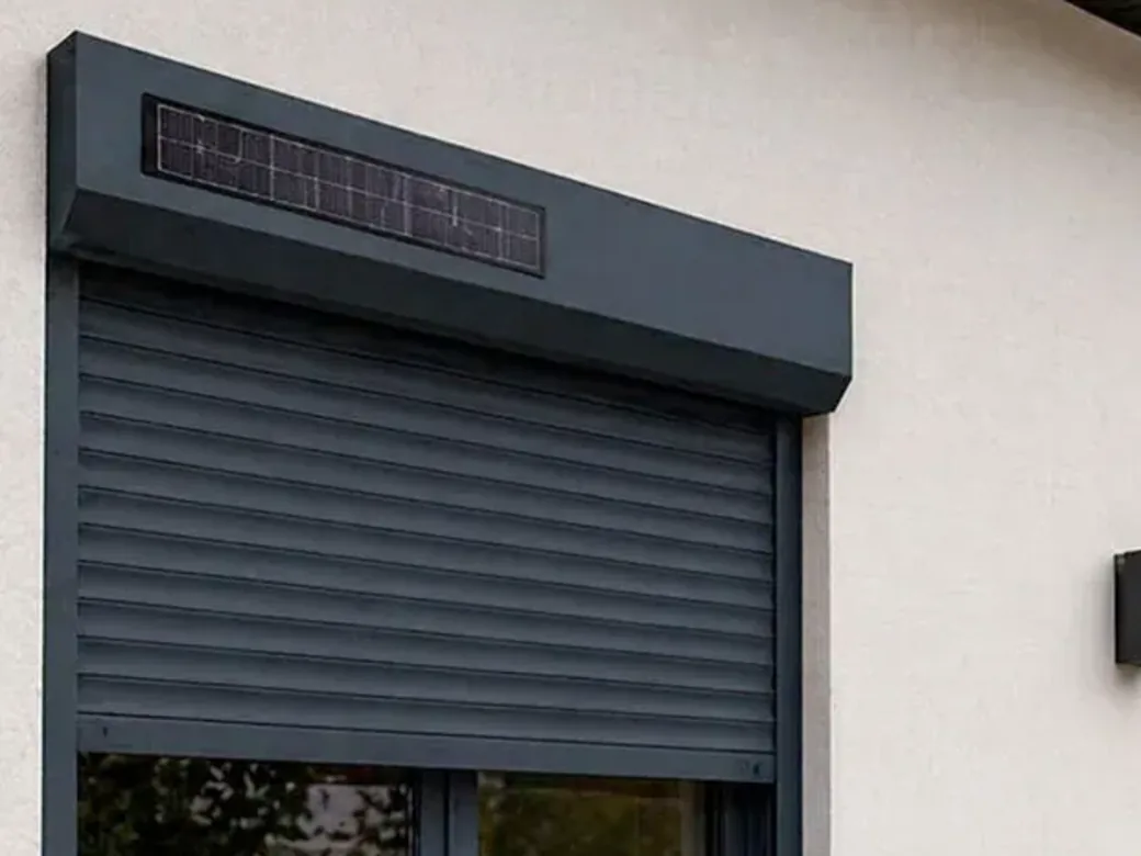 Coffre pan coupé anthracite d'un volet roulant solaire, avec son panneau photovoltaïque encastré