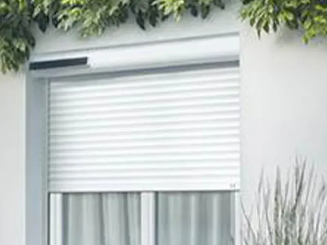 Volet roulant solaire blanc avec son panneau photovoltaïque discret sur le coffre