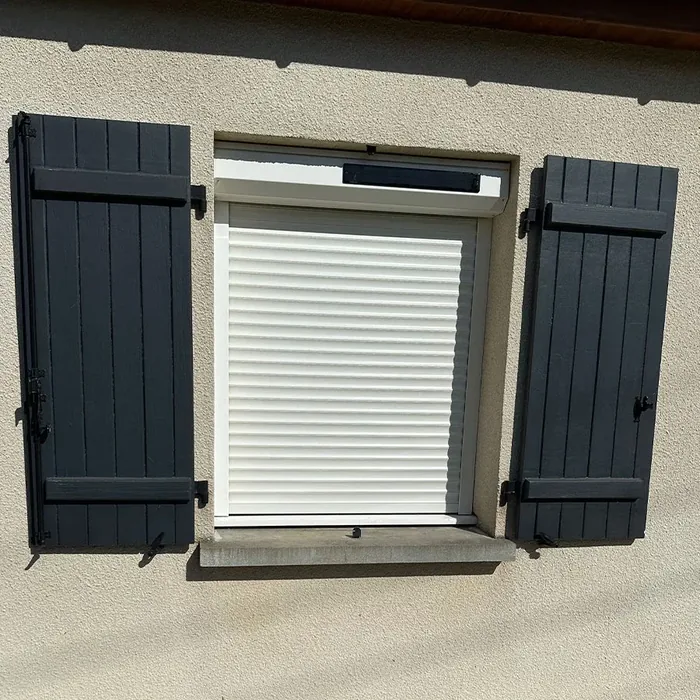 Volet roulant solaire blanc posé entre deux volets battants anthracite